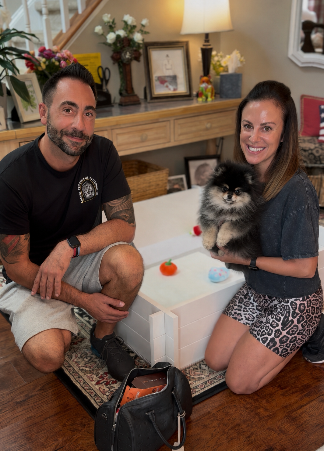 Couple at home with their new black and tan Pomeranian puppy from Cream-Puffs