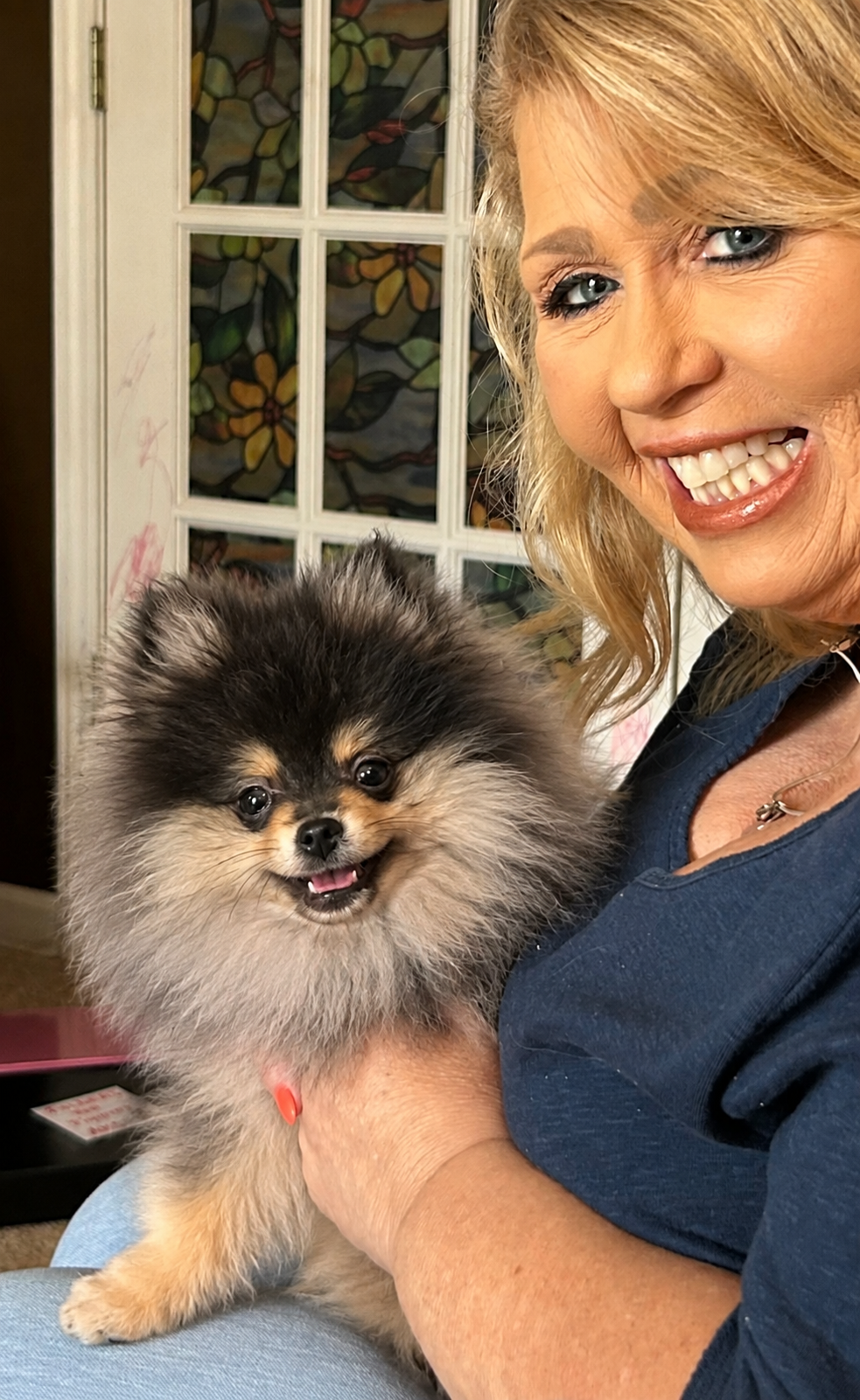 Woman smiling with her gorgeous black and tan Pomeranian puppy from Cream-Puffs